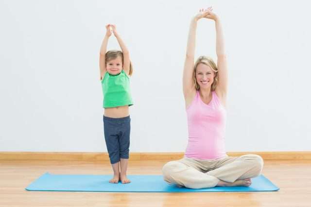 mom and daughter on yoga mat