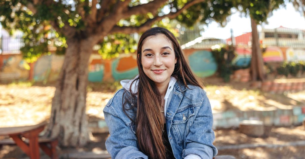 young woman smiling, looking at camera